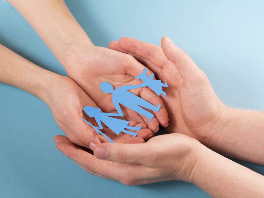 2 paar handen ineen met papieren poppetjes